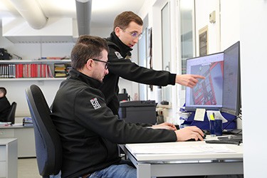 men looking at display on computer screens