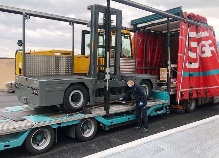 Large sideloader being loaded onto lorry